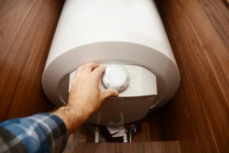 Man hand regulating heat of home boiler