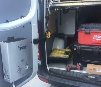 A tankless water heater installed at the back of a van
