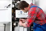 Technician troubleshooting a problem of a tankless water heater