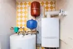 Indoor heating system with tank and tankless water heater