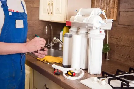 Plumber changing a water filter