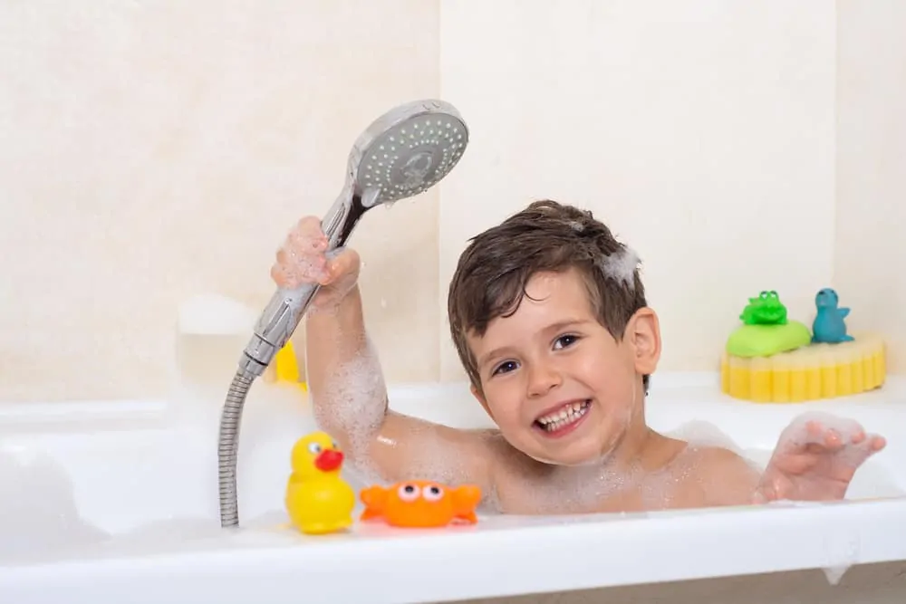 Kid bathing in a tub with shower