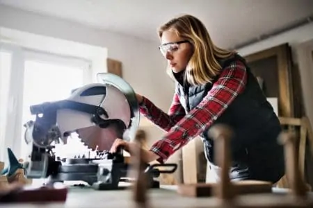 Woman operating a miter saw