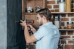 Man drilling living room wall with drill