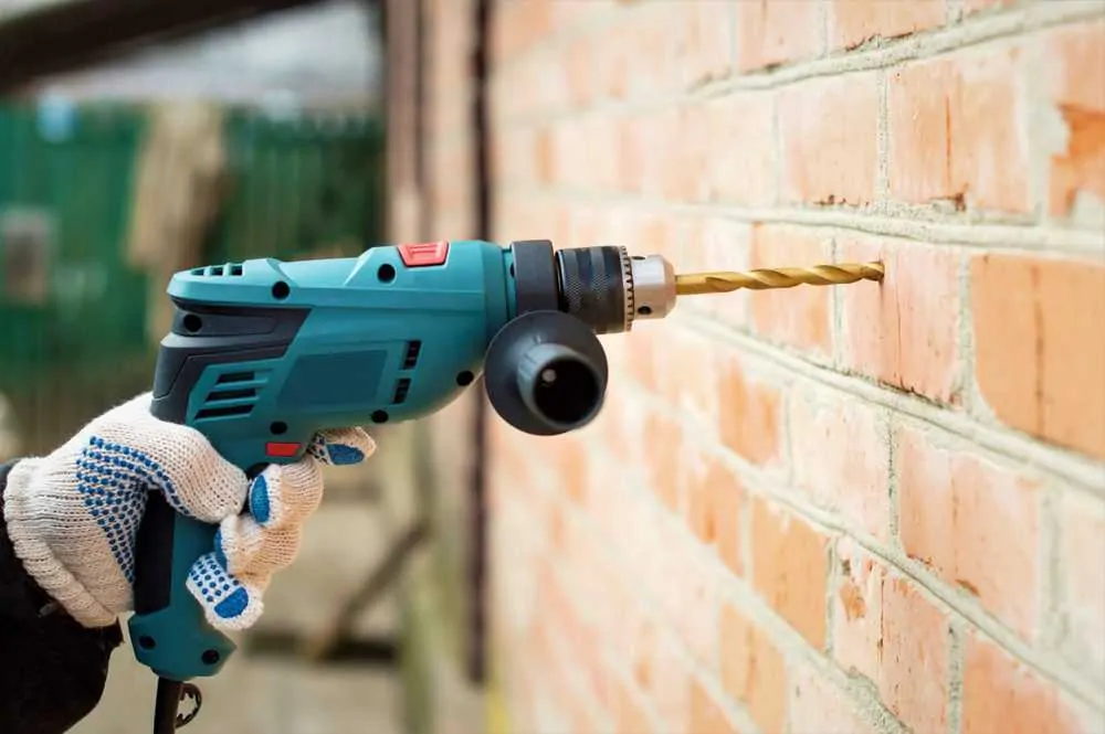 Electric drill against a brick wall