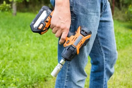 Man holding a battery powered impact wrench