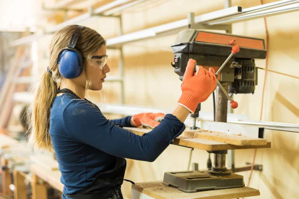 Woman working with a benchtop drill press