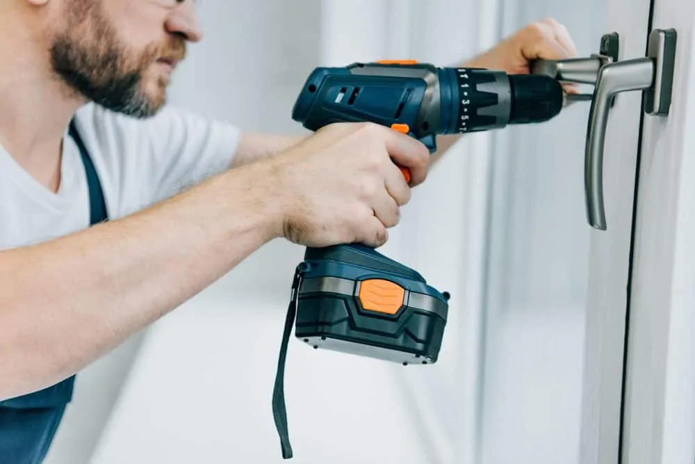 Man drilling into a lock with a cordless drill