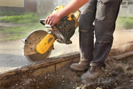 Man cutting concrete with a saw