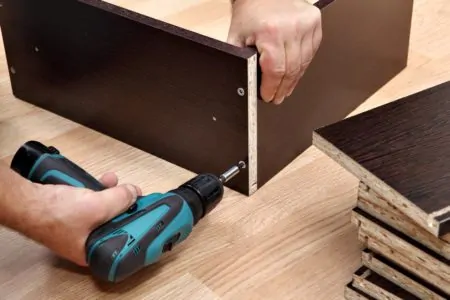 Man building a cabinet with a cordless screwdriver