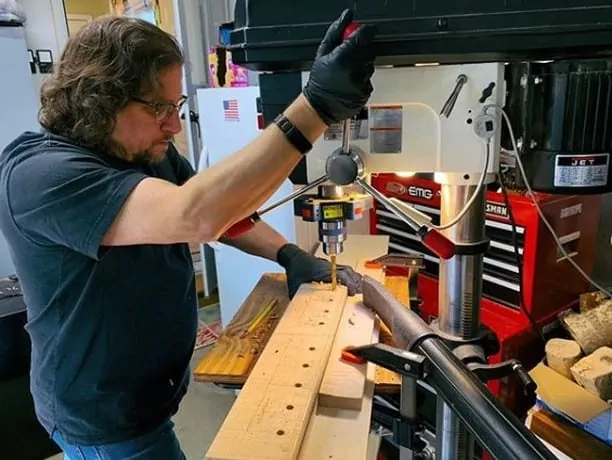 Man working with a floor drill press