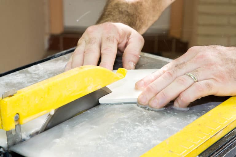 Man cutting ceramic tile with a table saw