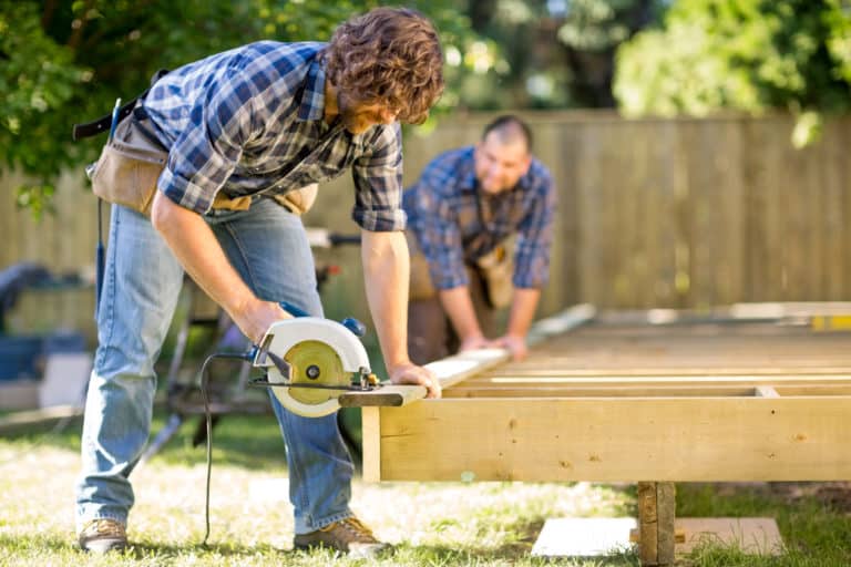 Carpenter cutting wood with a circular saw
