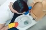 Man cleaning toilet with a toilet brush
