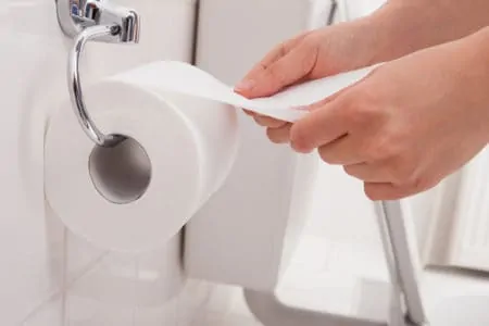 Woman pulling out toilet paper
