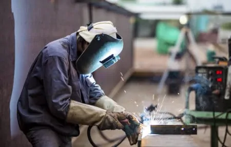 Worker with proective mask welding metal