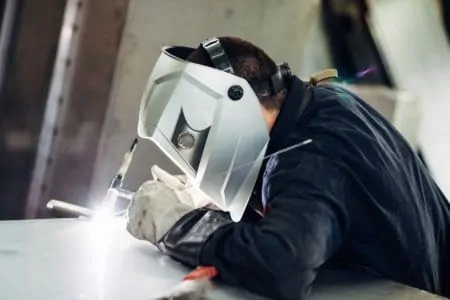 Man welding with head mask