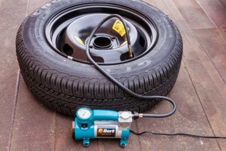 Inflating car tire with portable inflator
