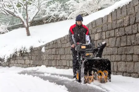 Man removing snow with a two-stage snow blower