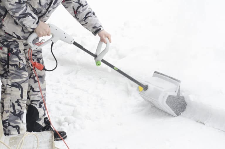 Man removing snow with electric snow shovel