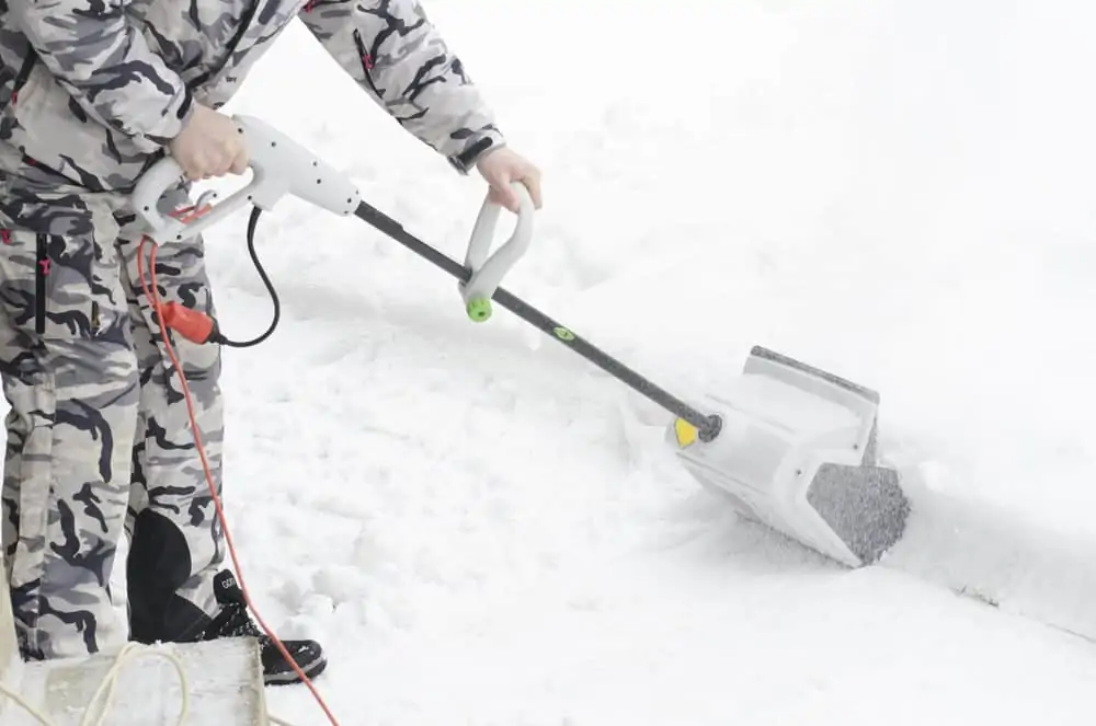 Man removing snow with electric snow shovel