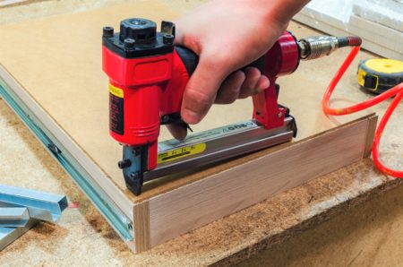 Pneumatic stapler nails the bottom to the drawer