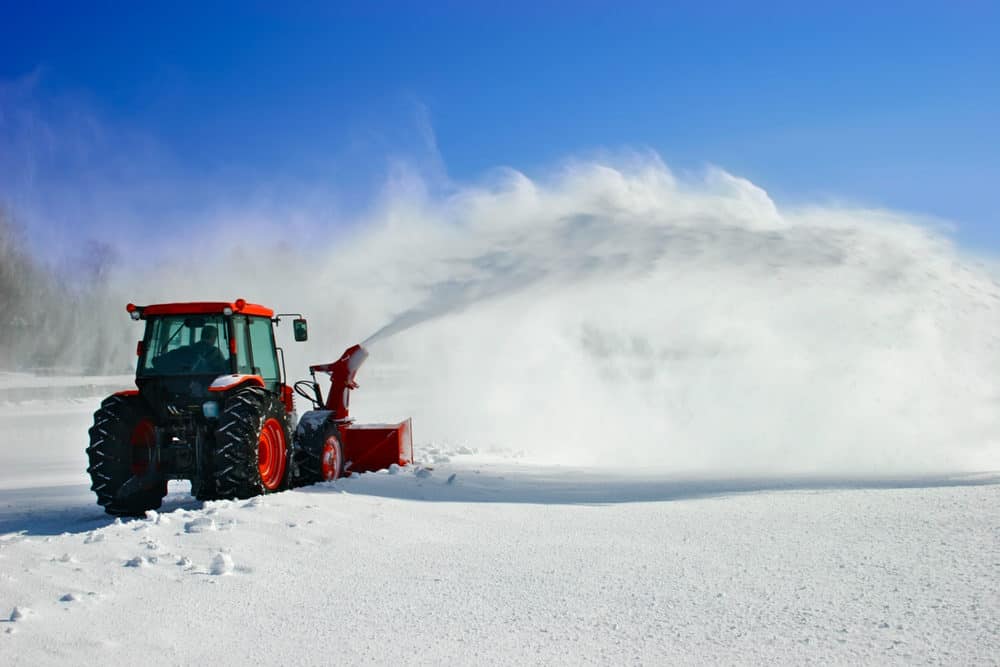 Tractor snow blower removing deep snow