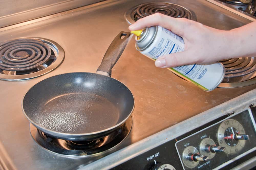 Spraying frying pan with cooking oil