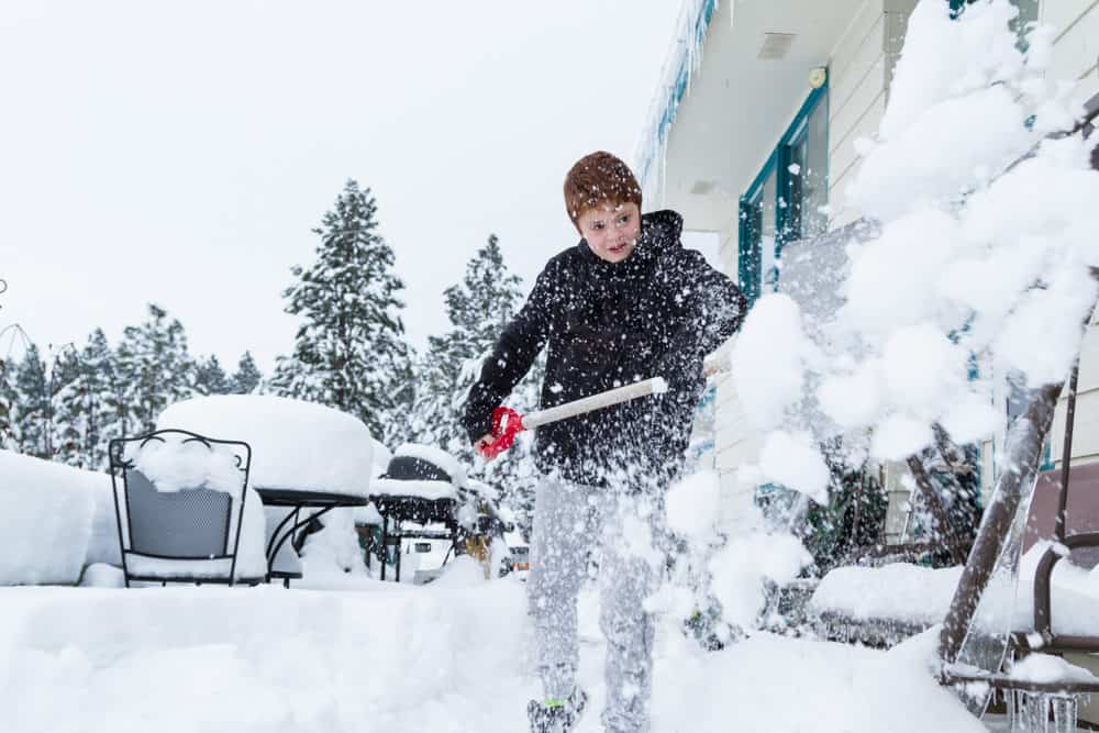 Young boy shoveling snow