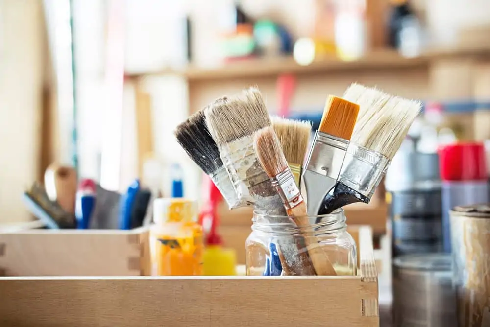 Paint brushes in a jar on the workshop table