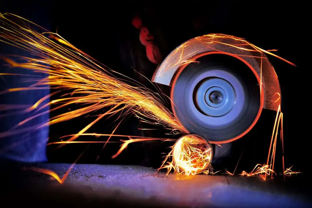 Worker cutting metal with a grinder