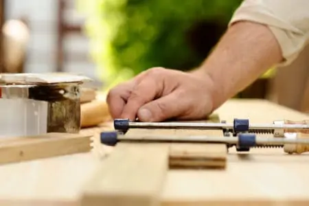 Carpenter hands at work with clamp