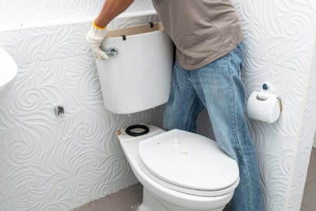 Man holding an empty toilet tank