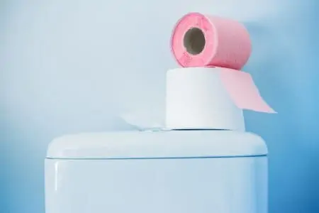 Pink toilet paper roll on a toilet tank