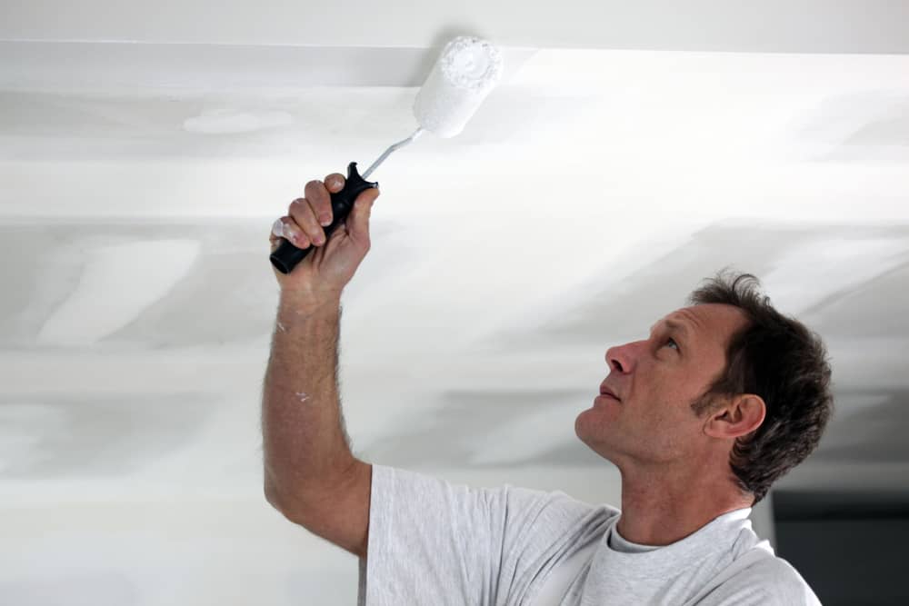 Man painting his ceiling white