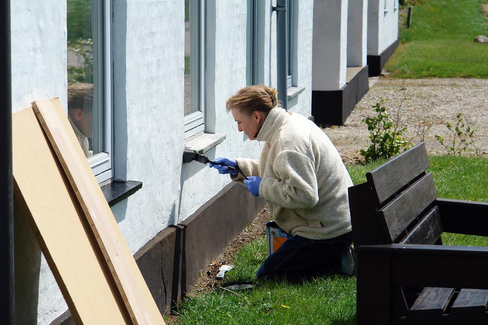 Woman painting exterior trim