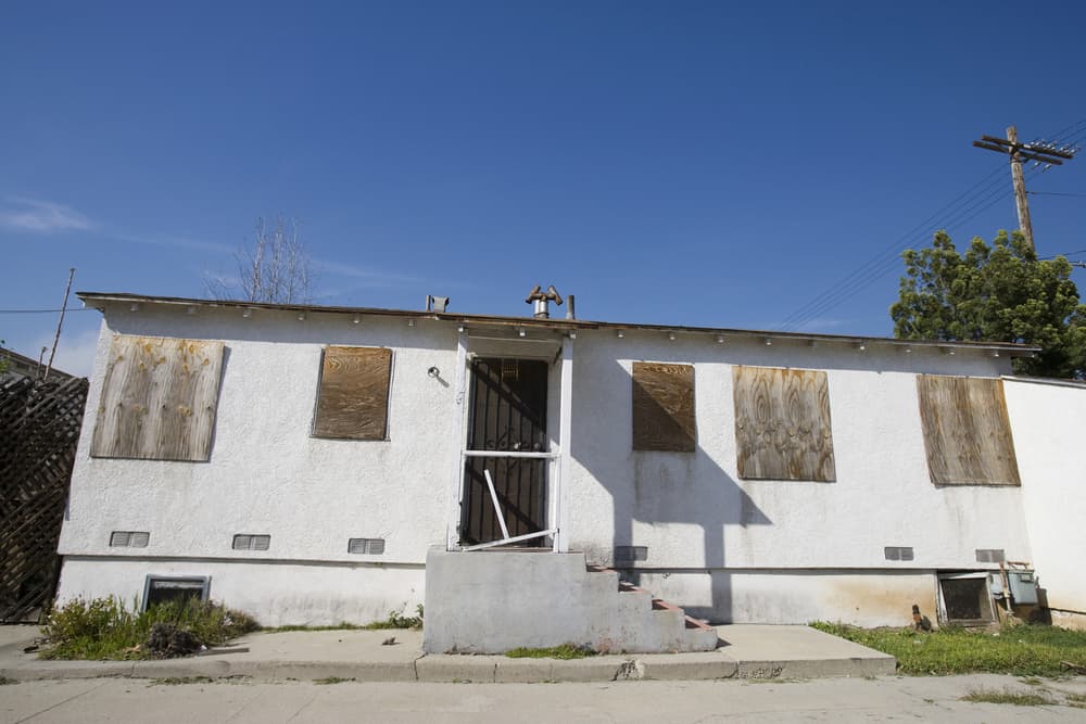 Exterior of an abandoned house with boarded up windows