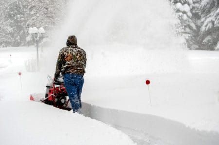 Man using a snow blower in deep snow