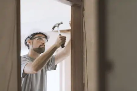 Professional carpenter installing a door jamb, home renovation and carpentry concept
