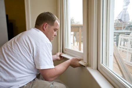 Carpenter repairing window frames, home is being updated to be sold