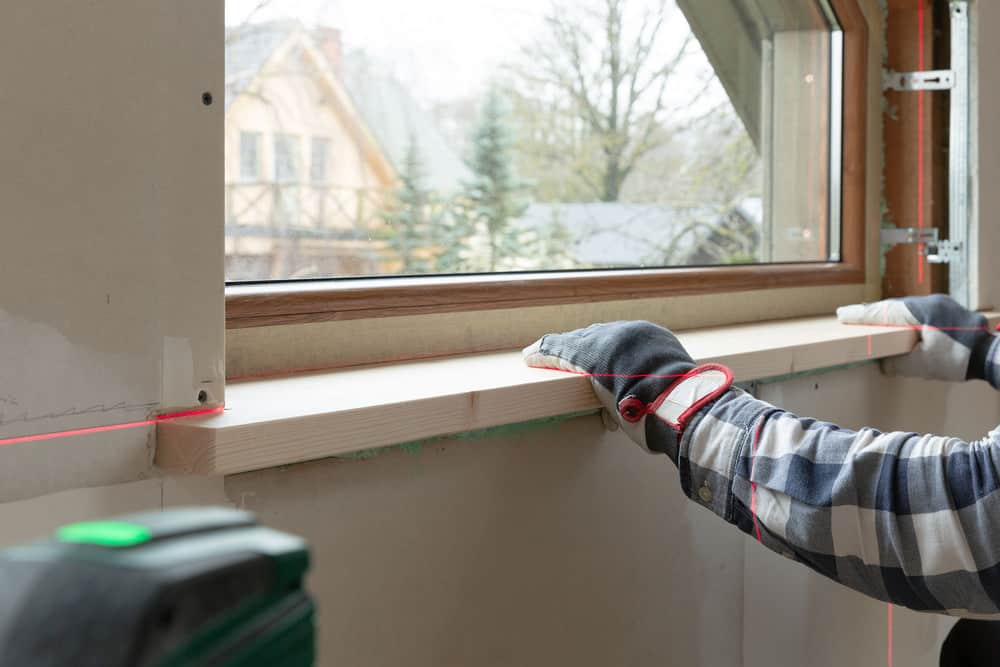 Home improvement handyman installing window sill
