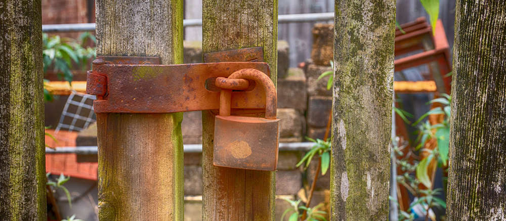 Rusty padlock on wooden gate