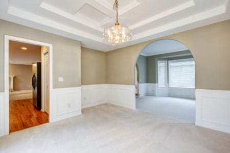 Empty luxury home interior with beige carpet of dining and living room.
