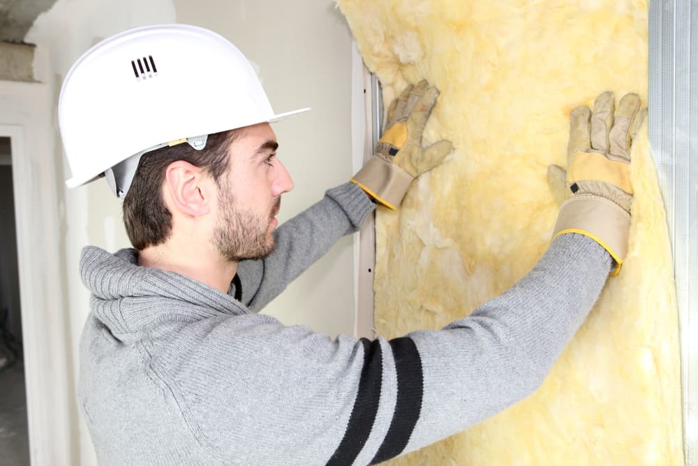 Man installing wall insulation