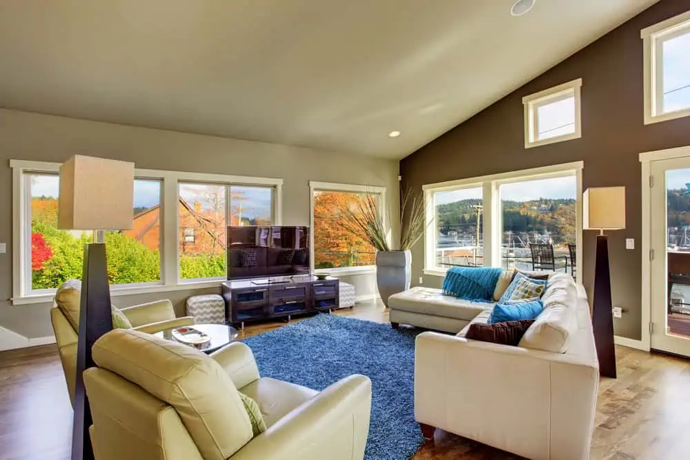 Huge living room interior with many windows and white leather sofa