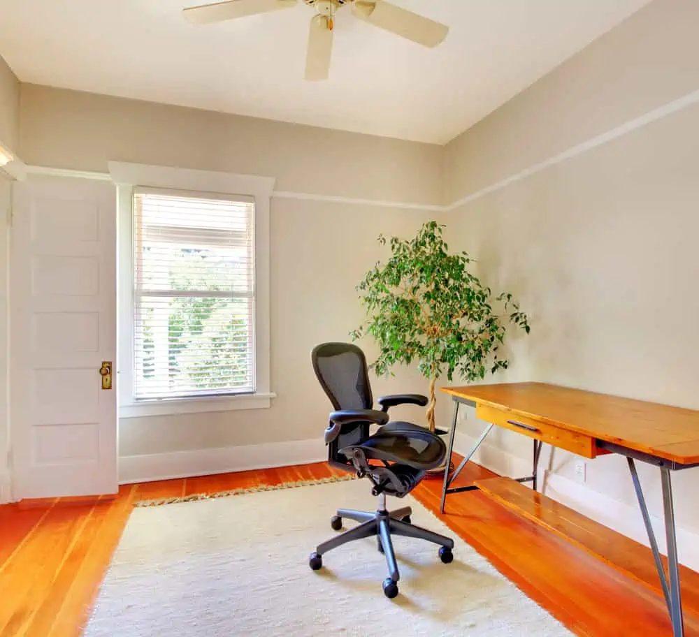 Home office room interior with desk and beige walls.