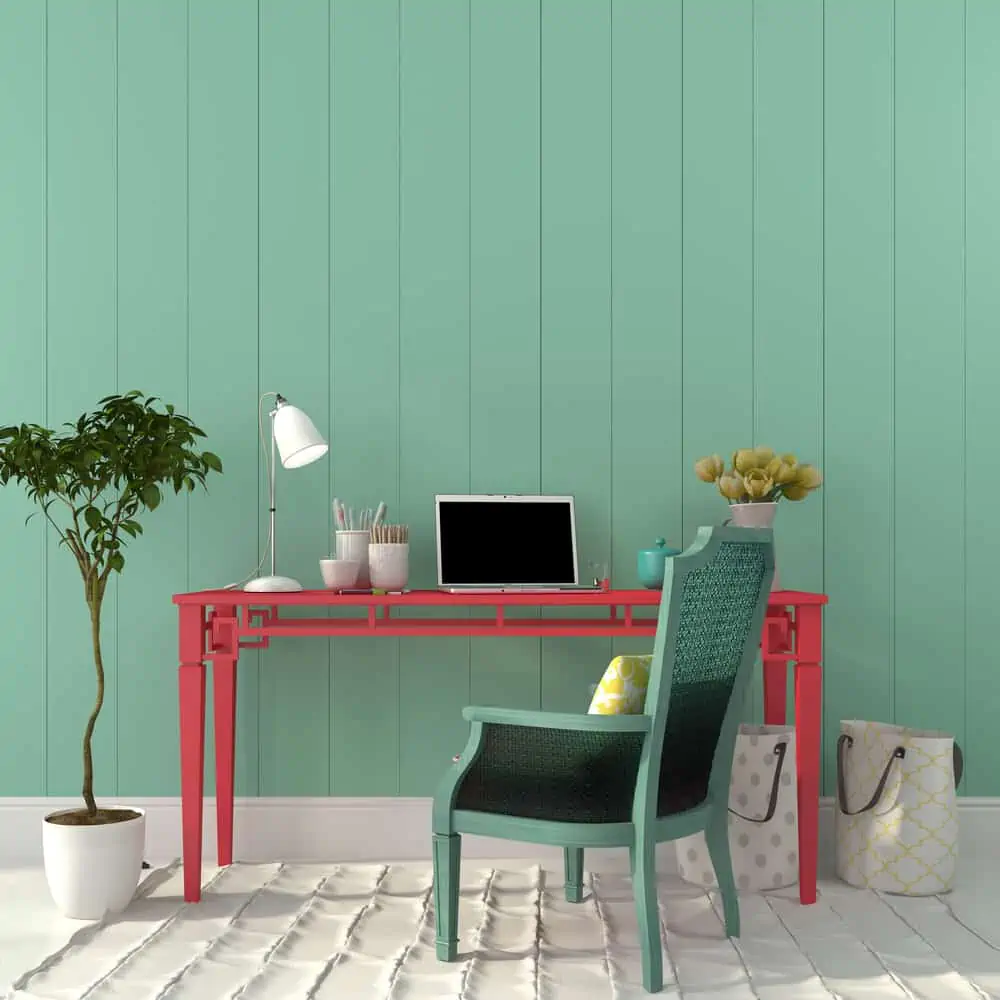 Interior of a home office of a pink desk and a turquoise chair