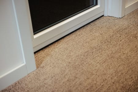 A carpeted floor covering and a closed door