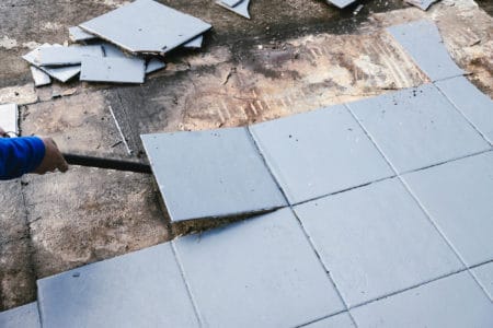 blue outdoor tiles getting ripped up to reveal concrete paving u