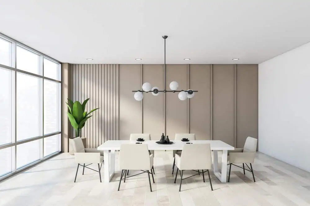 Interior of modern dining room with beige walls, wooden floor, long white table with white armchairs and stylish lamp. 3d rendering